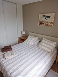 een slaapkamer met een bed met een gestreepte sprei bij Bidasoa con vistas in Hendaye