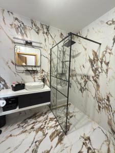 Un baño de mármol con lavabo y espejo. en Stylowy apartament z ogródkiem i tarasem, en Nysa