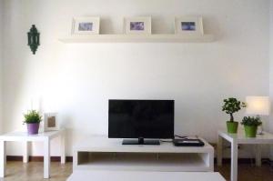 a living room with a tv and two tables with plants at Casa Paola in Tías