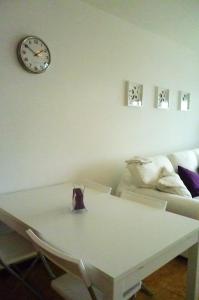 a living room with a table and a clock on the wall at Casa Paola in Tías