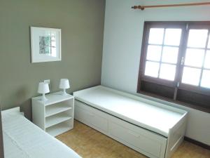 a bedroom with two beds and a window at Casa Paola in Tías +7 photos