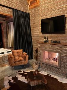 a living room with a fireplace and a chair at Sitio do Galdino in Armazém