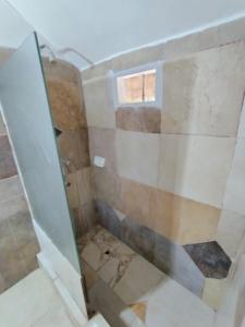 a shower with a glass door in a bathroom at Casa para 3 personas con patio in Barrio Félix U Camet
