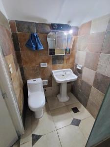 a bathroom with a toilet and a sink at Casa para 3 personas con patio in Barrio Félix U Camet