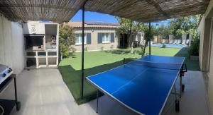 eine blaue Tischtennisplatte im Hinterhof in der Unterkunft Villa 200m2, 3 suites, patio avec salle jeux, 1 piscine CHAUFFE DE DEBUT AVRIL A FIN OCTOBRE in Maruéjols
