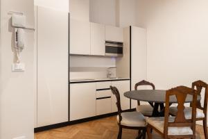 ボローニャにあるAzeglio Luxury roomのキッチン(テーブル、椅子、電子レンジ付)