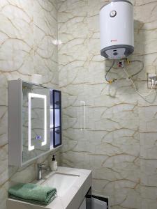 a bathroom with a sink and a light on a wall at Camara's Home in Sali Nianiaral