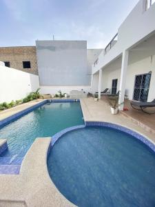 a large swimming pool in front of a building at Camara's Home in Sali Nianiaral