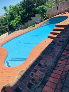 una piscina vuota con scale e acqua blu di Edladleni Holiday Accomodation a Durban