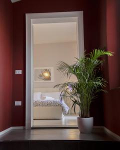 a bedroom with a mirror and a potted plant at "le Volte" Appartamento nel cuore di Foligno in Foligno