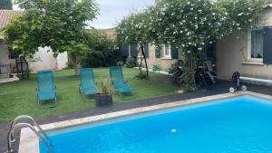 einen Garten mit Stühlen und einem Pool in der Unterkunft Villa 200m2, 3 suites, patio avec salle jeux, 1 piscine CHAUFFE DE DEBUT AVRIL A FIN OCTOBRE in Maruéjols