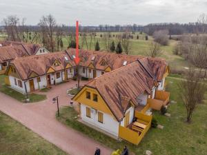 a group of houses with brown roofs in a field at Marjetica 40 in Moravske-Toplice