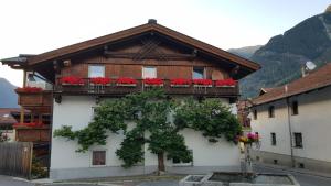 a building with red flowers on the balcony at Arche Ötztal Dorfzentrum in Umhausen