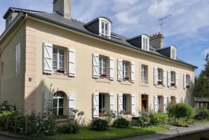 een oud huis met witte ramen en planten bij residence fleurie rdc in Saint-Malo