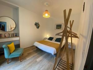 a bedroom with a bed and a chair and a mirror at residence fleurie rdc in Saint Malo