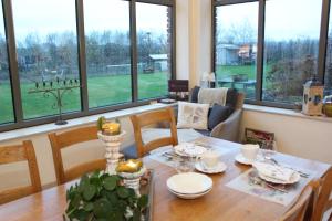 a dining room with a table and chairs and windows at Widdingenhof in Wellen