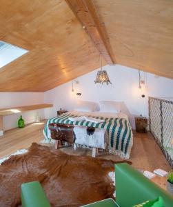 a bedroom with a large bed in a attic at Ribeira d'ilhas Shelter in Santo Isidoro