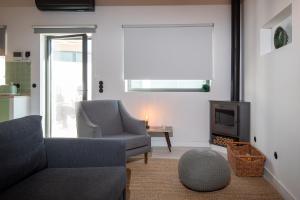 a living room with a couch and a chair and a tv at Ribeira d'ilhas Shelter in Santo Isidoro +24 photos