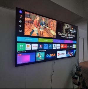 Un televisor de pantalla plana colgado en una pared en Lapland Villa Ulpukka, en Rovaniemi