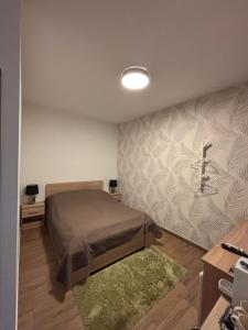 a small bedroom with a bed and a rug at Beugró Lak in Esztergom