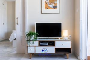 a living room with a tv on a dresser at Bliss On The Bay Apartment in La Herradura