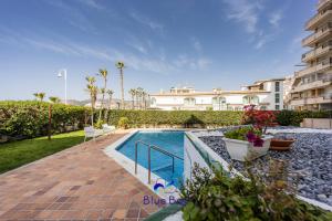 a swimming pool in front of a building at Bliss On The Bay Apartment in La Herradura