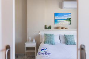 a bedroom with a bed with a blue box sign on it at Bliss On The Bay Apartment in La Herradura +40 photos