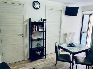 a dining room with a table and a clock on the wall at Archetto-casa vacanze in Enna