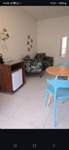 a living room with a table and a blue chair at Suites Nativa in Ubatuba