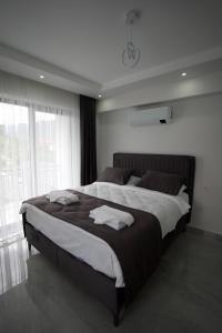 Una cama grande en un dormitorio con una ventana grande. en MSD Konakları, en Muğla