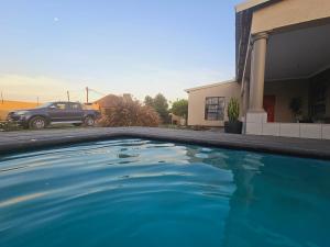 una piscina azul frente a una casa en Morokolotsi Guest House, en Tzaneen