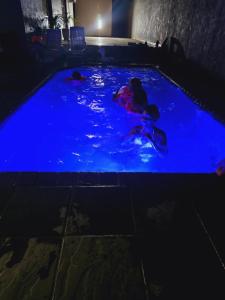 two people swimming in a pool at night at Morokolotsi Guest House in Tzaneen +18 photos