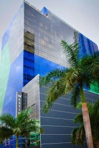 a tall glass building with palm trees in front of it at The Westin Panama in Panama City