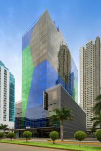a tall glass building with trees in front of it at The Westin Panama in Panama City