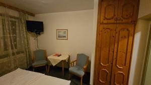 a room with a bed and two chairs and a table at Gasthof Linko in Traisen +8 photos