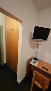a room with a desk with a computer and a television at Gasthof Linko in Traisen
