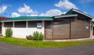 un edificio con un grande garage in legno con tetto verde di Apartamento Daly 3 a Guápiles