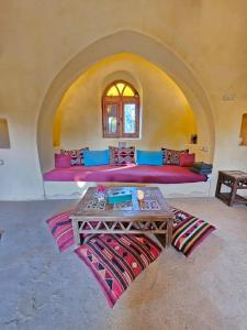 a room with a bed with a table in it at Beit Ain al Haya in Fayoum