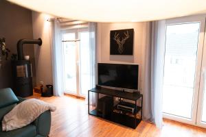 a living room with a television and a couch at Ferienhaus Glücklich am Harz in Goslar