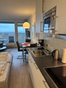 a kitchen with a sink and a living room at Am Südwesthorizont App 185 in Timmendorfer Strand