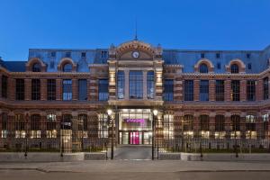 a large building with a clock on top of it at Moxy Lille City in Lille