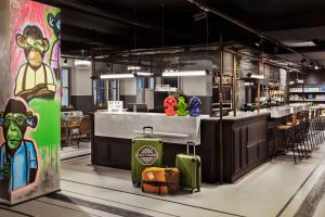 un restaurant avec un bar et un comptoir avec des bagages dans l'établissement Moxy Lille City, à Lille