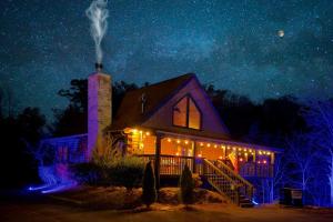 a house with christmas lights on it at night at Ryes and Shine Bootlegger's Cabin! Hot Tub* Pool* Arcade* Billiards *EV * Pet Friendly in Sevierville