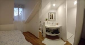 a white bathroom with a sink and a mirror at Le Moulin des Roses in Neslette