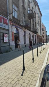 Moti Apartments في كراكوف: شارع فيه صف من الاعمدة السوداء على الرصيف