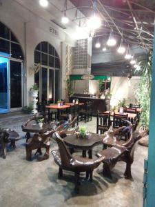 un restaurante con mesas, sillas y mesas de madera en The Grand Palace Hostel, en Bangkok