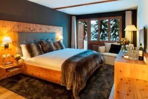 een slaapkamer met een groot bed met een houten hoofdeinde bij La Val Hotel & Spa in Brigels