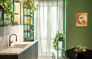 a kitchen with a sink and a window with plants at MONART HOSPITALITY Vesuvio Park in Ottaviano