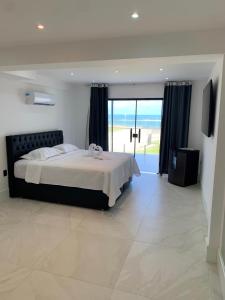 a bedroom with a bed with a view of the ocean at Pousada Casa Branca in Extremóz +20 photos