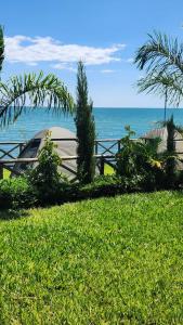 Mfangano IslandArch-Villa Resort&Camping Site Mfangano Island的坐在靠近海洋的草地上的船